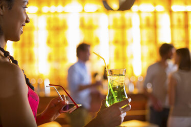 Young woman with cocktail and sunglasses in club - CUF41503