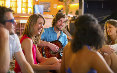 Freunde genießen das Gitarrenspiel in einer Bar - CUF41514