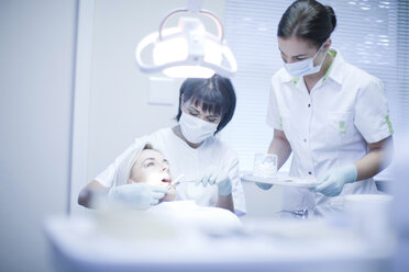 Dentist and nurse treating patient - CUF41531