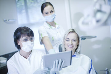 Dentist and patient looking at digital tablet - CUF41537