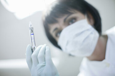 Close up portrait of dentist holding syringe - CUF41544