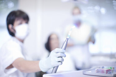 Close up of dentists hand holding ultraviolet light - CUF41546