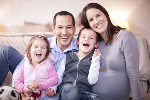 Porträt eines werdenden Paares mit zwei kleinen Kindern, lizenzfreies Stockfoto