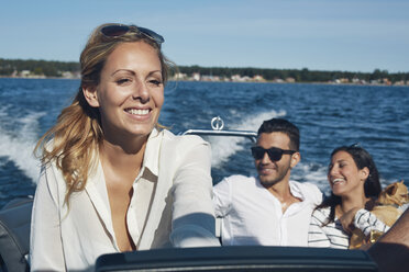 Junge Frau steuert Boot mit Freunden im Hintergrund, Gavle, Schweden - CUF41645