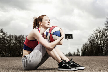 Woman hugging netball to chin - CUF41827