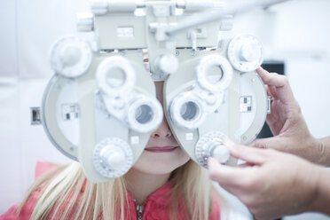 Optician testing young girl in eye clinic - CUF41910