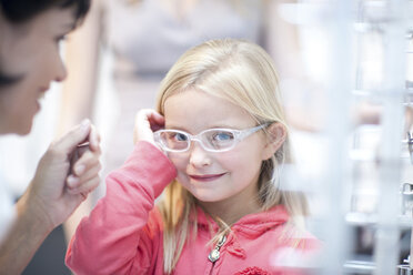 Junges Mädchen bei der Auswahl einer Brille - CUF41911