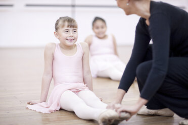 Lehrerin stellt die Füße einer jungen Ballerina ein - CUF41916