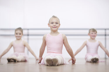 Young ballerinas in pose whilst sitting on floor - CUF41919