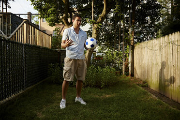 Mann hält Fußball im Garten - CUF41932