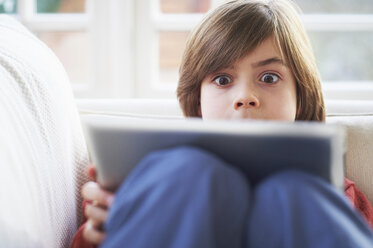 Junge auf Sofa mit digitalem Tablet - CUF41945