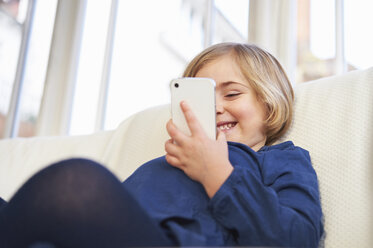 Mädchen auf Sofa mit Smartphone - CUF41954