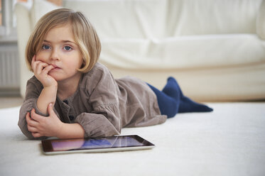 Girl lying on floor using digital tablet - CUF41957