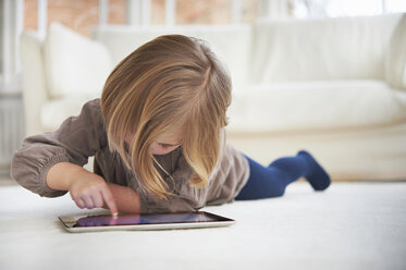 Mädchen auf dem Boden liegend mit digitalem Tablet - CUF41958