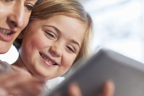 Mutter und Tochter benutzen ein digitales Tablet - CUF41963