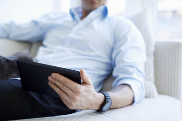 Cropped shot of man's midsection holding digital tablet - CUF41974