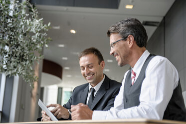 Zwei Geschäftsleute vor einem digitalen Tablet - CUF42037
