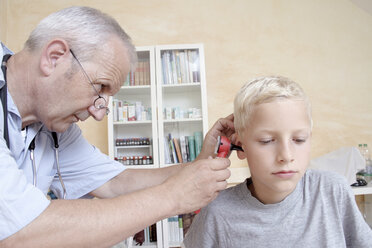 Arzt untersucht das Ohr eines Jungen - CUF42093