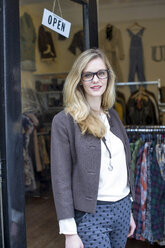 Woman standing outside clothes shop - CUF42099