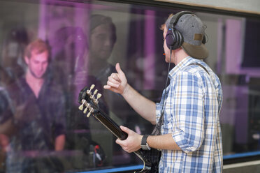 Junger Gitarrist im Aufnahmestudio - CUF42126