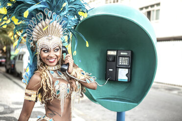 Samba dancer using pay phone, Ipanema Beach, Rio De Janeiro, Brazil - CUF42303