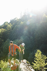 Two rock climbers standing on rocks in sunlight, Chamonix, Haute Savoie, France - CUF42381