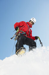 Mittlerer erwachsener Mann beim Klettern im Schnee, niedriger Winkel - CUF42393