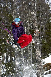 Skifahrer, der mitten in der Luft über Bäume springt, Are, Schweden - CUF42443