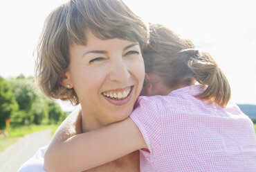 Mother holding daughter, smiling - CUF42450