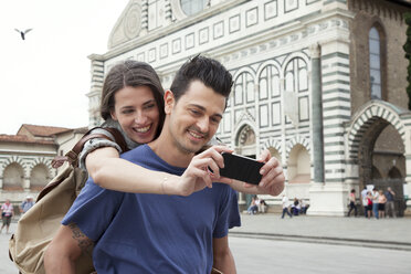 Young couple outside Santa Maria Novella church, Florence, Tuscany, Italy - CUF42640