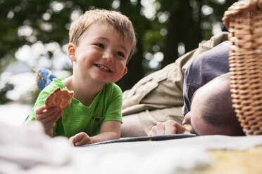 Boy enjoying picnic with father - CUF42666