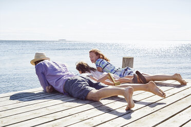 Familie auf dem Pier liegend, Utvalnas, Gavle, Schweden - CUF42678