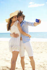 Couple self photographing with mobile phone on beach - CUF42695
