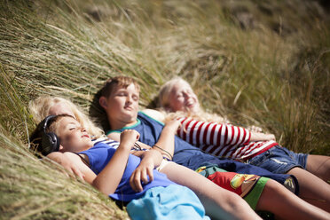 Vier Freunde entspannen in den Dünen, Wales, UK - CUF42714