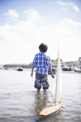 Porträt eines Jungen, der mit einem Modellboot spielt - CUF42725