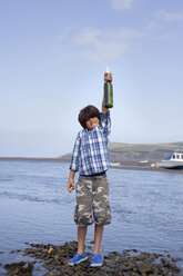 Junge mit Flaschenpost am Meer - CUF42726