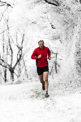Mann läuft im Winter durch den Wald, Wenlock Edge, Shropshire, England, UK - CUF42739