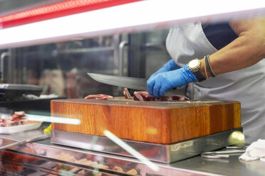 Woman slicing ham on chopping block - AFVF00769