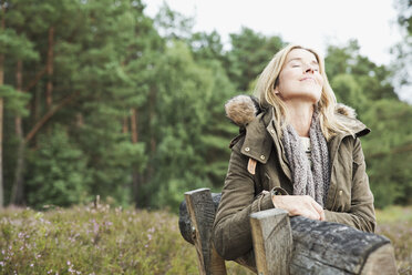 Mid adult woman on bench with eyes closed - CUF42777