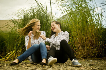 Two young women laughing in breeze - CUF42794