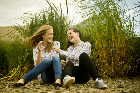 Zwei junge Frauen lachen in einer Brise - CUF42794