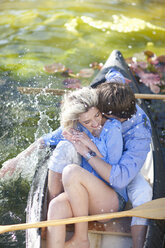 Junges romantisches Paar, das im Ruderboot herumalbert - CUF42802
