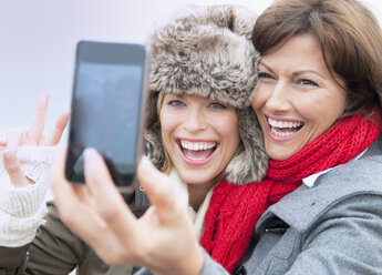 Two female friends taking self portrait at coast, Thurlestone, Devon, UK - CUF42809