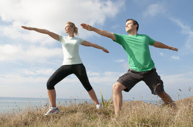 Mid adult couple exercising on cliff top, Thurlestone, Devon, UK - CUF42812