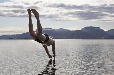 Mann taucht ins Wasser, Aure, Norwegen - CUF42814