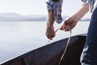 Man on boat with rope, Aure, Norway - CUF42815