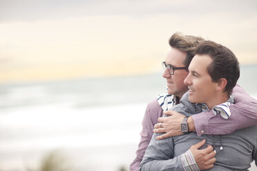 Schwules Paar umarmt sich am Strand - CUF42869