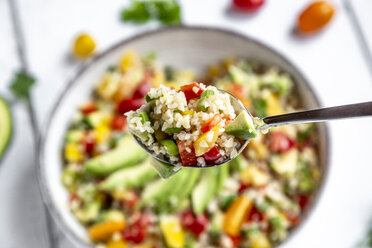 Spoon of bulgur salad with bell pepper, tomatoes, avocado, spring onion and parsley - SARF03832