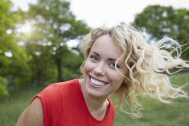 Portrait of smiling blond woman wearing red t-shirt outdoors - PNEF00762
