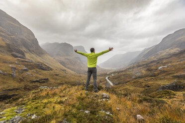 UK, Schottland, Mann im schottischen Hochland bei Glencoe mit Blick auf die Three Sisters - WPEF00681